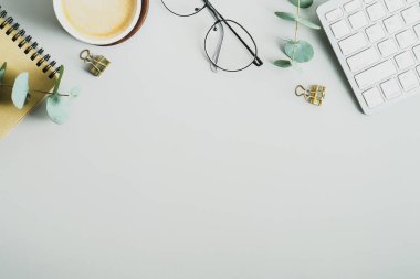 Üst kattaki ofis masasında yatıyordu. Çalışma alanı, kahve, klavye, bardak, yeşil arka planda kağıt defter. Kadınsı çalışma alanı, minimalist tarz, iş konsepti
