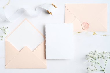 Zarif düğün davetiyesi şablonu ve mermer taşın üzerindeki zarflar. Düğün kırtasiye seti. Düz konum, üst görünüm, kopyalama alanı.