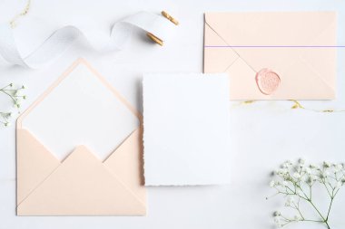 Zarif düğün davetiyesi şablonu ve mermer taşın üzerindeki zarflar. Düğün kırtasiye seti. Düz konum, üst görünüm, kopyalama alanı.