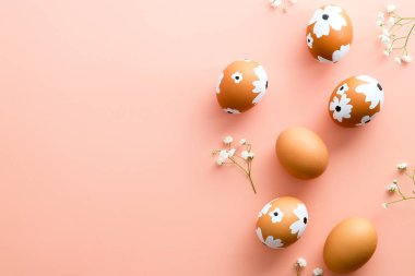 Mutlu Paskalya kartı tasarımları. Pastel pembe arka planda renkli Paskalya yumurtalarından yapılmış çerçeve. Düz konum, üst görünüm, kopyalama alanı.