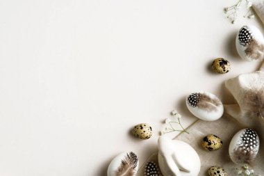 Mutlu Paskalya kartı tasarımları. Paskalya yumurtaları Paskalya tavşanı ile süslenmiş tüyler, beyaz masada çiçekler..