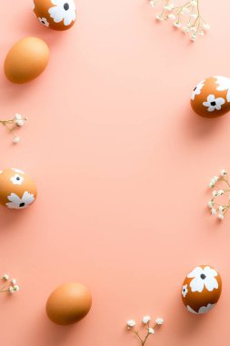 Mutlu Paskalya bayrağı tasarımı. Paskalya yumurtalarından yapılmış çerçeve pastel pembe arka planda süslenmiş çiçekler. Düz konum, üst görünüm, kopyalama alanı