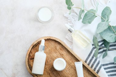 Doğal SPA organik kozmetik seti tahta tahta, havlu, okaliptüs dalı ve banyo taşı masa. Düz yatış, üst görünüm.