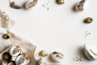 Paskalya düzlüğü kompozisyonu. Beyaz arka planda tüyleri olan Paskalya yumurtaları. Mutlu Paskalya kartı şablonu.