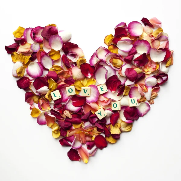 Heart of rose petals with the words: love you — Stock Photo, Image