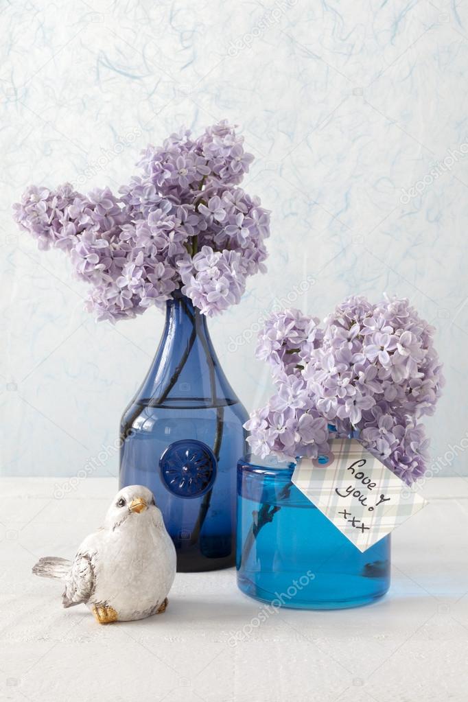 Lilacs in blue vases and a card with the words: Love you