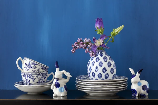Still life with blue and white dishes and flowers in a little va — Stock Photo, Image
