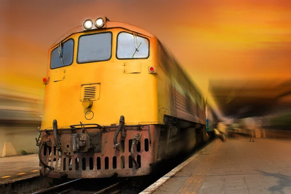 Trein passerende in oranje zonsondergang — Stockfoto