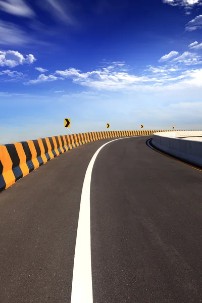 Kromme verkeersbord met blauwe hemel — Stockfoto