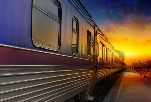 Trein passerende in oranje zonsondergang — Stockfoto