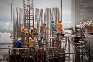 Building under construction with workers clipart