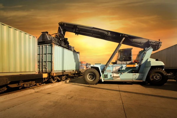 Kraan opheffen van container in zonsondergang — Stockfoto