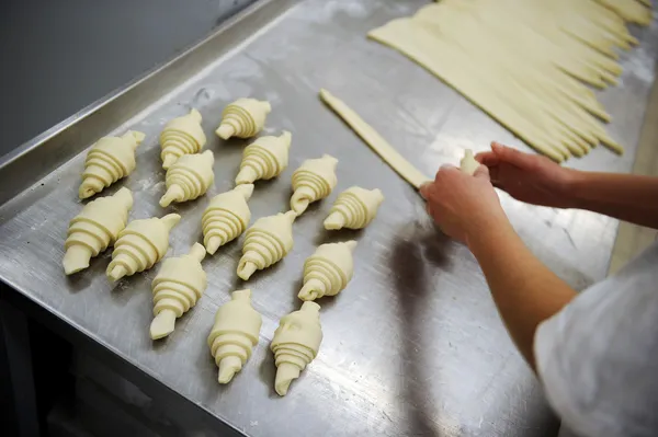 Baker egy croissant-t alkotó — Stock Fotó