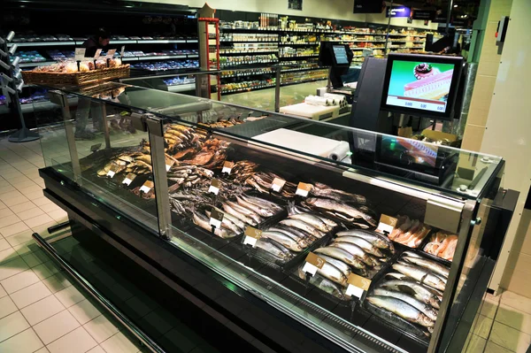 Prateleiras totalmente carregadas com peixes em um grande supermercado — Fotografia de Stock