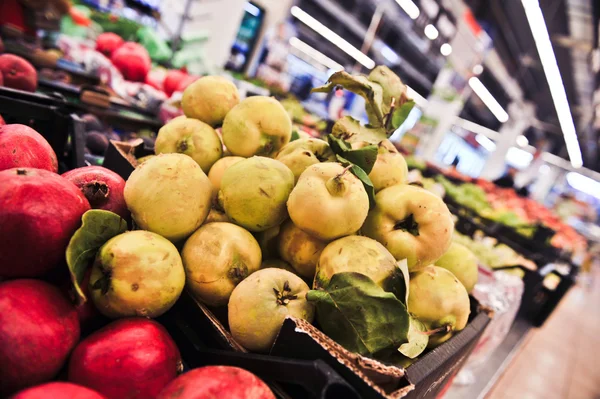 Stelletje gele kweepeer in supermarkt. groothoek schot — Stockfoto