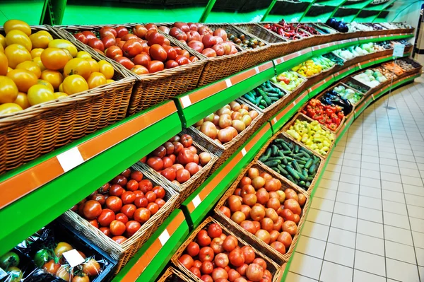 Schappen met groenten in een winkel — Stockfoto