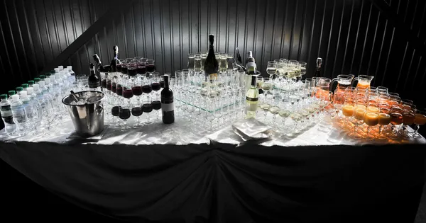 Bril met wijn op tafel - feestachtergrond Rechtenvrije Stockafbeeldingen