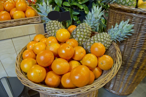 Апельсины и ананасы на рынке — стоковое фото