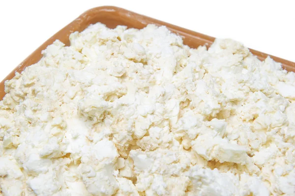 Süzme peynir pişmiş süt beyaz zemin üzerinde bir plaka ile — Stok fotoğraf