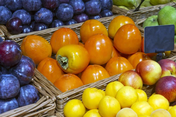 Saftiga mogen sharonfrukt på marknaden — Stockfoto