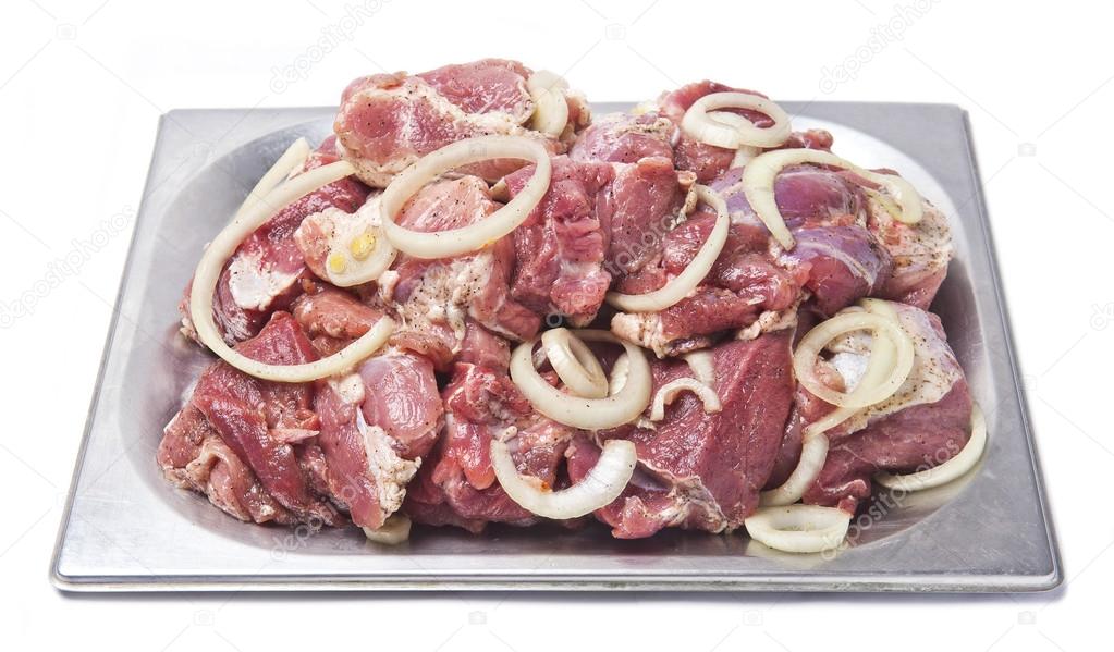 raw meat with onion rings for a kebab in a metal plate