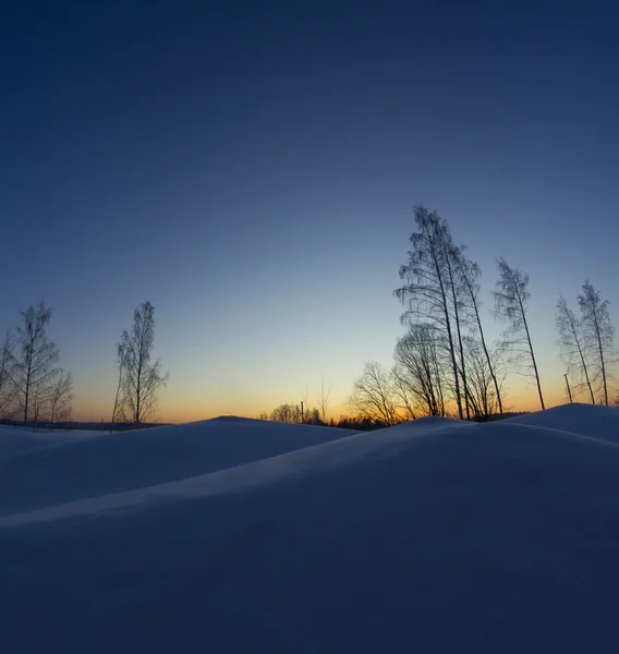 Besneeuwde landschap, zonsondergang in koude winterlucht. Rechtenvrije Stockfoto's