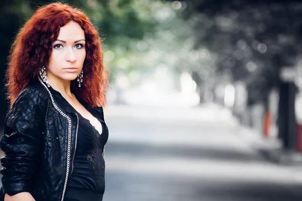 Chica con el pelo rojo en los árboles verdes callejón — Foto de Stock