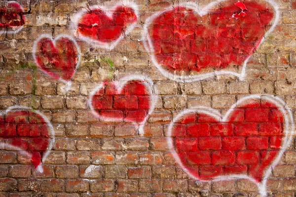 Rote Herzen auf eine Ziegelwand gemalt — Stockfoto