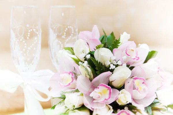 Düğün buketi ve arka planda şarap bardakları — Stok fotoğraf