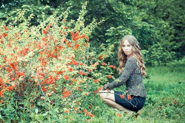 Vacker flicka i blommande park — Stockfoto