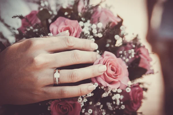Hände und Ringe am Brautstrauß Stockfoto