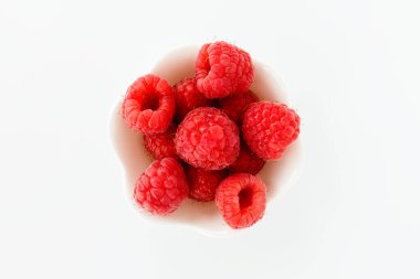 Beyaz arka planda izole edilmiş şirin beyaz bir kasede taze ahududu. Üst görünüm.