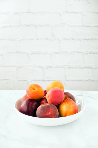 Ganze Pfirsiche Nektarinen Und Aprikosen Einer Weißen Porzellanschale Auf Weißem — Stockfoto