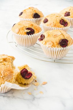 Ön planda ev yapımı vişneli kek ve arka planda soğutma rafında kekler. Düşük açı görünümü.