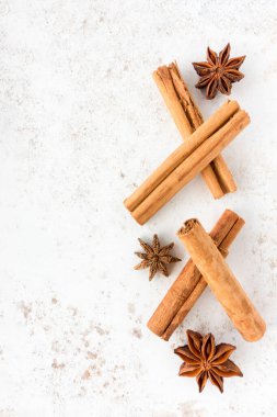 Seylan tarçın çubukları ve yıldız anason beyaz benekli arka planda bir sürü fotokopi alanı. Üst görünüm.