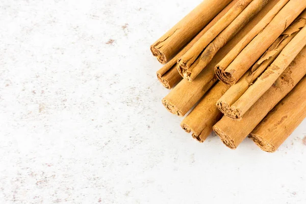 Closeup Pile Long Cinnamon Sticks White Speckled Background Copy Space — Stock Photo, Image