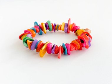 Canlı gökkuşağı renklerinde taze su kabuğu bileziği beyaza izole edilmiş. El yapımı mücevherler. Düşük açı. Özellik sürümü sanatçı tarafından imzalandı.