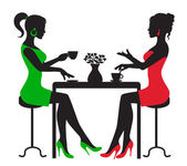 Two women drinking coffee at a table