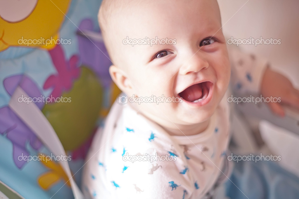 Laughing baby showing first milk tooth