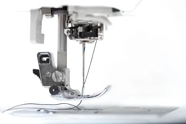 beyaz zemin üzerine iğne closeup bölümüyle dikiş makinesi