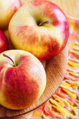 ahşap masa ve plaka üzerinde taze kırmızı elmalar