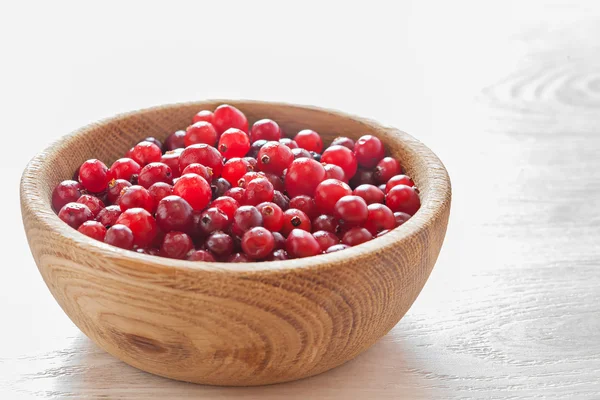 Cranberries em prato de madeira — Fotografia de Stock