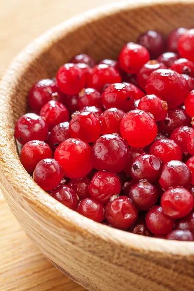 Cranberries vermelhas em prato de madeira — Fotografia de Stock