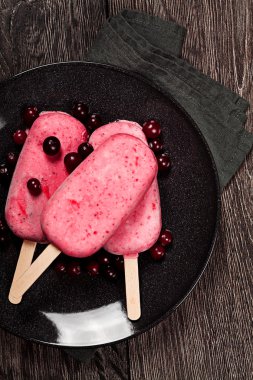 koyu arka plan üzerinde popslice çilekli dondurma