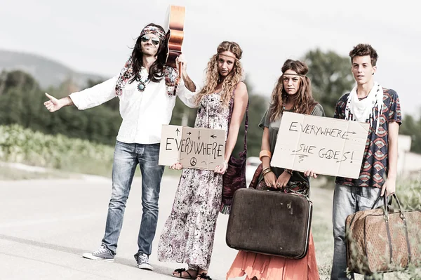 Hippie skupina stopování na venkově road — Stock fotografie
