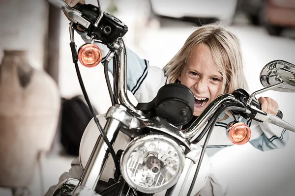 Kind schurk rijden op een motorfiets Rechtenvrije Stockfoto's