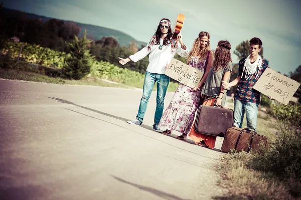 Hippie groep liften op een weg van het platteland Rechtenvrije Stockfoto's