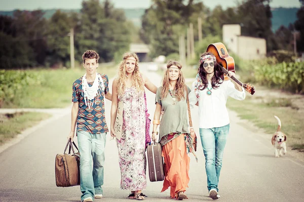 Hippie groep liften op een weg van het platteland Stockfoto