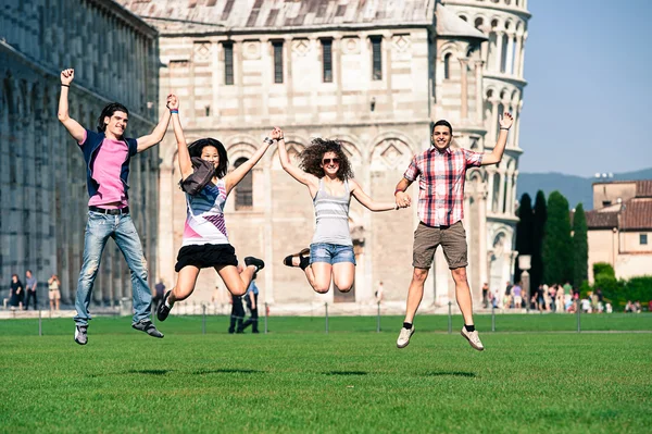 Grupo de amigos saltando con Pisa torre inclinada en el fondo — Foto de Stock