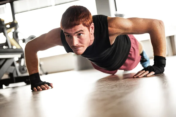 Sterke, knappe man doen push-ups in een sportschool als bodybuilding exe — Stockfoto